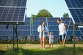 Enthusiastic father showing potential of alternative energy. Contemporary family looking at new solar station they