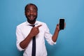 Enthusiastic happy person pointing at smartphone blank screen