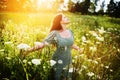 Happy woman among wildflowers on a summer day