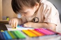 Enthusiastic male kid drawing multicolor rainbow paper sheet closeup early development art activity