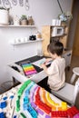 Enthusiastic male kid drawing multicolor rainbow paper sheet closeup early development art activity