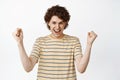 Enthusiastic male model showing winner pose, celebrating victory, screaming from excitement, white background