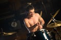 Enthusiastic male musician playing drum set in garage