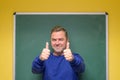 Enthusiastic male teacher giving double thumbs up