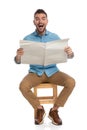 Enthusiastic man reading newspaper and laughing Royalty Free Stock Photo