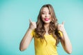 Enthusiastic motivated attractive young woman giving a thumbs up gesture of approval and success Royalty Free Stock Photo