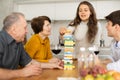 Enthusiastic parents and adult children play exciting game Jenga at home Royalty Free Stock Photo