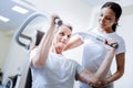 Enthusiastic pensioner using exercise equipment in a rehabilitation center