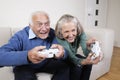 Enthusiastic senior couple playing video game at home