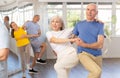 Enthusiastic senior couple practicing jive in group dance class Royalty Free Stock Photo