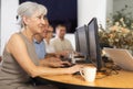 Enthusiastic senior woman attending computer class for older adults