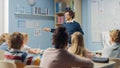 Enthusiastic Teacher Explains Lesson to a Classroom Full of Bright Diverse Children, Teaches Geome Royalty Free Stock Photo