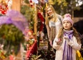 Enthusiastic teenager girl picking tree decorations at street market