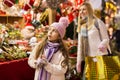 Enthusiastic teenager girl picking tree decorations at street market