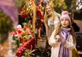 Enthusiastic teenager girl picking tree decorations at street market