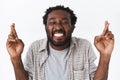 Enthusiastic and upbeat, happy hopeful african-american guy cant wait wish come true, fingers crossed smiling and close