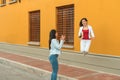 Enthusiastic woman jumping in the street and looking at her friend Royalty Free Stock Photo