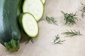 Entire raw zucchini and several pieces with fennel on wooden background Royalty Free Stock Photo