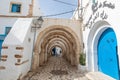 the entrance arch of old covered suq in Hawna as Suq with arabic letter meaning club de tunisie