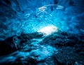 Entrance of an crystal blue ice cave with underground river inside, Vatnajokull glacier, Iceland