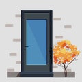 The Entrance Door Is Dark Blue With A Large Window, A Handle And A Lock. Stairs To The Door And A Brick Wall With A Tree