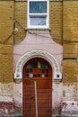 The entrance door of an old brick building with stucco molding, a fragment of the facade