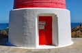 The entrance door of the red and white striped lighthouse at Cape Palliser on North Island, New Zealand. The light was built in Royalty Free Stock Photo