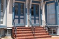 Entrance door to a large stone house with a porch. Glass door, window and stone steps Royalty Free Stock Photo