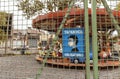 old abandoned carousel with sign saying (mask obligatory