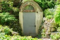 Entrance door to an old basement, park landscape