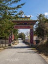 Entrance gate to a Buddhist temple with symbols, flags and stupas