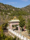 Entrance gate to a Buddhist temple with symbols, flags and stupasd