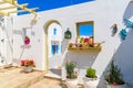 Entrance gate to typical Greek style apartments decorated with flower pots on street in Naoussa town on Paros island, Greece Royalty Free Stock Photo