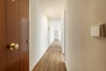 Entrance hall with an armored door of an empty house with a long corridor leading to multiple rooms Royalty Free Stock Photo