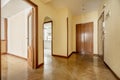 Entrance hall of a house with cherry wood door, herringbone oak parquet flooring, access to multiple rooms, fitted wardrobes and