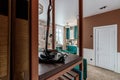 Entrance hall in a modern apartment made in retro style with bookshelves and a green pouf and a sofa