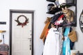 An entrance hall with outerwear on a hanger, a pet cat sitting in a basket on a shelf for hats. Mess in the hall. The front door Royalty Free Stock Photo