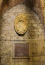 Entrance of a historic building adorned with a plaque in Perugia, Italy