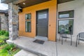 Entrance of a house with black front door and two arm chairs