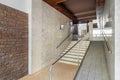 Entrance of a house with long corridor, stairs to elevator area with ramp for disabled person wheelchair, brick and