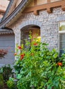 Entrance of a luxury house with a patio and beautiful landscaping on a sunny day. Garden in front of detached house Royalty Free Stock Photo