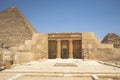 entrance of the mastaba of Seshemnufer IV late 5th Dynasty and the Great Pyramid in background. The Pyramid Fields from Giza to Royalty Free Stock Photo