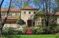 Entrance of a modern Upscale stucco house in spring with pink and white azeleas and tree leaves just starting to bud out Royalty Free Stock Photo