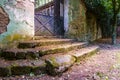 Entrance in an old mansion with stairs full of leaves and a rusty fence Royalty Free Stock Photo