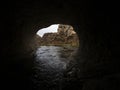 Entrance opening hole of dark black natural water tunnel at Broken River Cave Stream Reserve, Canterbury, New Zealand Royalty Free Stock Photo