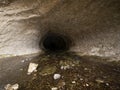 Entrance opening hole of dark black natural water tunnel at Broken River Cave Stream Reserve, Canterbury, New Zealand Royalty Free Stock Photo