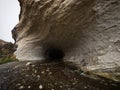 Entrance opening hole of dark black natural water tunnel at Broken River Cave Stream Reserve, Canterbury, New Zealand Royalty Free Stock Photo