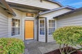 Entrance porch with yellow front door and large windows