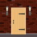 Entrance retro door with torches on the sides. Entrance door made of wood on a brick wall background.