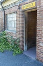 ENTRANCE sign above open door of red brick commercial building shows a dark wood interior. Royalty Free Stock Photo